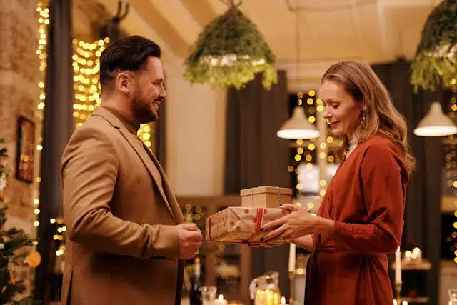 A young couple exchanging Christmas presents.