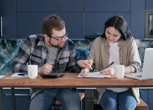 A young couple creating a budget in their living room. 