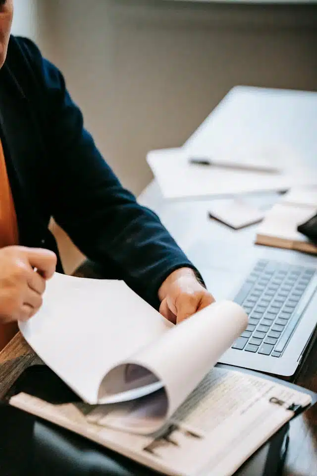 A person organizing and reviewing documents for a title loan application. 